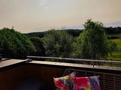 a balcony with a view of a field and trees at Tiny House Dreiländereck in Neu-Moresnet