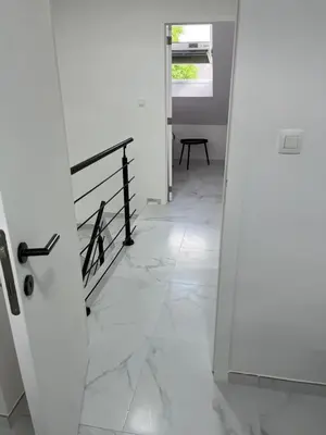 a hallway with white marble floors and a door at DEDIA Guest Home