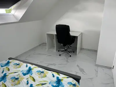 a bedroom with a desk with a chair and a bed at DEDIA Guest Home