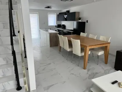 a kitchen and dining room with a wooden table and chairs at DEDIA Guest Home