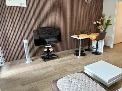 a living room with a television and a table at Appart de Lux , 3 borders , free parking , in La Calamine
