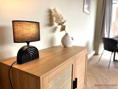 a lamp sitting on top of a wooden dresser at Le 180 escapade face à la Meuse in Liège
