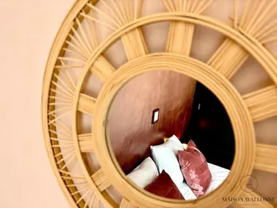 a circular mirror in a hotel room with a bed at Le 180 escapade face à la Meuse in Liège