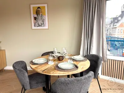 a dining room table with chairs and a table with glasses at Le 180 escapade face à la Meuse in Liège