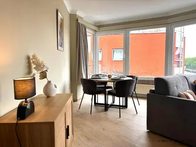 a living room with a table and chairs and a couch at Le 180 escapade face à la Meuse in Liège