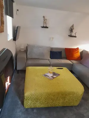 a living room with a couch and a yellow ottoman at Felicita in Jalhay