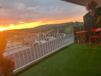a balcony with a view of the sunset at Central peak of Embourg Apartment in Chaudfontaine