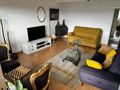 a living room with a couch and a television at Central peak of Embourg Apartment in Chaudfontaine