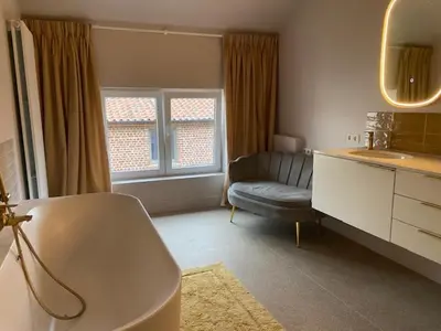 a bathroom with a sink and a couch in a room at Cièlo in Tongeren