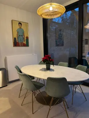 a dining room table with chairs and a vase of flowers at Cièlo in Tongeren