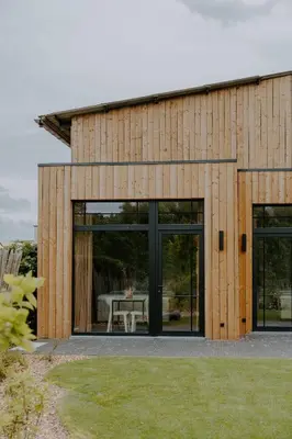 a house with large glass doors and a table in front at Hangar C gastensuites in Heers