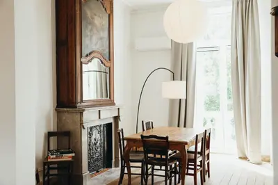 a dining room with a table and chairs and a fireplace at Simonis, Parc de la Boverie by WelcHome in Liège