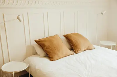 a white bed with two pillows on top of it at Simonis, Parc de la Boverie by WelcHome in Liège
