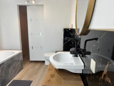 a bathroom with a sink and a toilet and a mirror at Petite maison typique en Outremeuse - 2 à 4 personnes in Liège