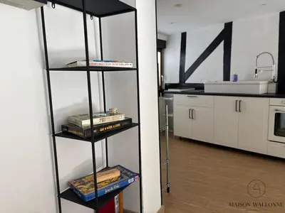a book shelf in a kitchen with books at Petite maison typique en Outremeuse - 2 à 4 personnes in Liège