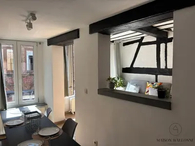 a living room with a table and a window at Petite maison typique en Outremeuse - 2 à 4 personnes in Liège