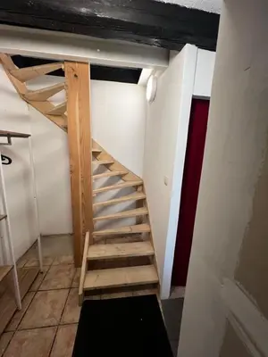a wooden staircase in a room with a wall at Petite maison typique en Outremeuse - 2 à 4 personnes in Liège