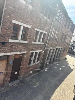 a brick building with windows on the side of it at Petite maison typique en Outremeuse - 2 à 4 personnes in Liège
