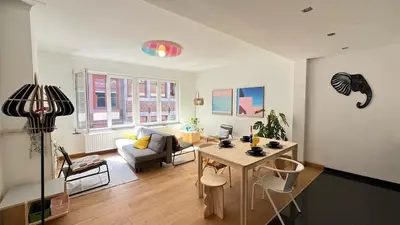 a living room with a table and a couch at Cozy Neuvice apartment in Liège