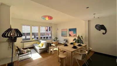 a living room with a couch and a table and chairs at Cozy Neuvice apartment in Liège