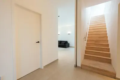 a hallway with a door leading up to a staircase at Bocca in Hasselt