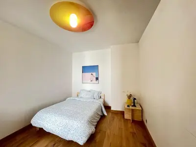 a bedroom with a bed and a yellow light at 102 Cozy Neuvice in Liège