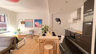 a kitchen and living room with a table in a room at 102 Cozy Neuvice in Liège