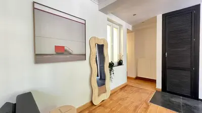 a living room with a guitar on the wall at 201 Loft Lumineux en Hyper-Centre in Liège