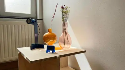 a vase with flowers in it on a table at 201 Loft Lumineux en Hyper-Centre in Liège