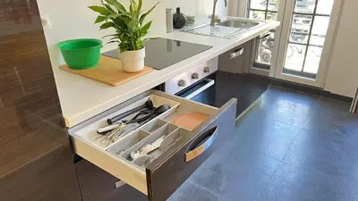 a kitchen with a sink and a drawer with utensils at 201 Loft Lumineux en Hyper-Centre in Liège