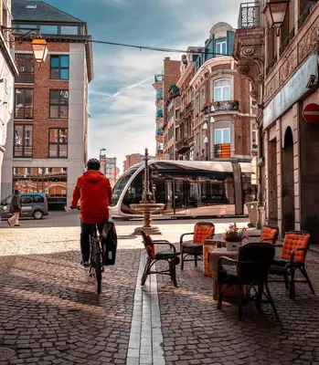 a person riding a bike down a street at 302 Le Spot Neuvice in Liège