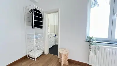 a white walk in closet with a mirror at 301 Loft Chic Central in Liège
