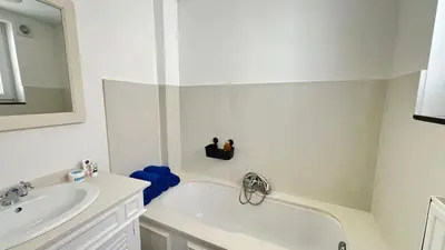 a white bathroom with a sink and a bath tub at 301 Loft Chic Central in Liège