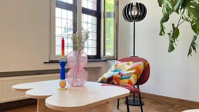 a table with a vase and a chair in a room at 301 Loft Chic Central in Liège