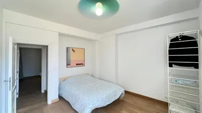 a white bedroom with a bed and a closet at 301 Loft Chic Central in Liège