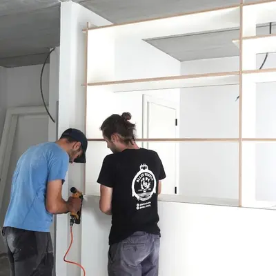two men are painting a wall in a room at 303 Loft design Cathéderale in Liège