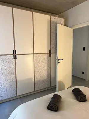 a bedroom with white cabinets and a bed with two towels at 303 Loft design Cathéderale in Liège