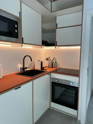 a kitchen with white cabinets and a sink at 303 Loft design Cathéderale in Liège