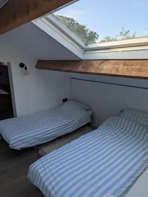 two beds in a room with a window at Vacation on the farm in Lanaken