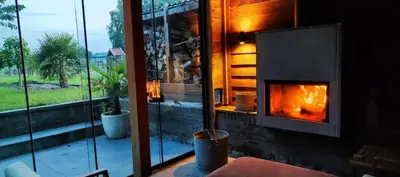 a fireplace in a room next to a window at Vacation on the farm in Lanaken