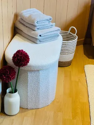 a pile of towels and a vase with a flower at Appartement rustique à Liège in Liège