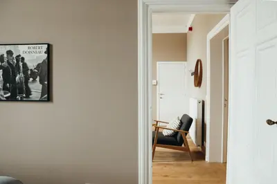 a hallway with a chair and a picture on the wall at Liège Centre-ville by WelcHome in Liège