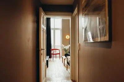 a hallway with a door open to a room with a chair at Liège Centre-ville by WelcHome in Liège