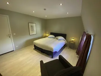 a bedroom with a bed and a couch in it at Liège Carré by WelcHome in Liège