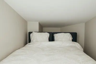 a white bed with two pillows on top of it at Liège Carré by WelcHome in Liège