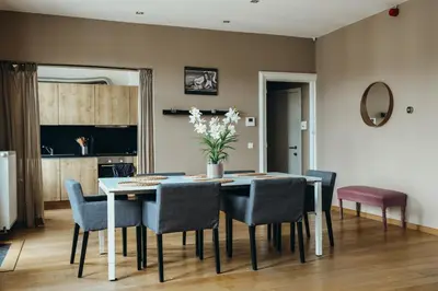 a dining room table with chairs and a vase of flowers at Liège Carré by WelcHome in Liège