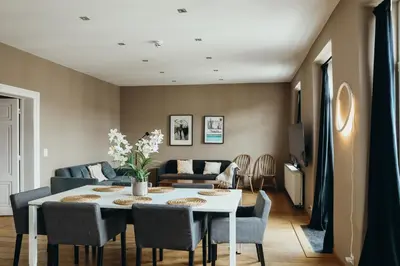 a living room with a table and chairs at Liège Carré by WelcHome in Liège