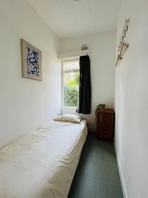 a small bedroom with a bed and a window at Boshuisje June - middenin de natuur op een uurtje rijden van Antwerpen en Maastricht in Balen