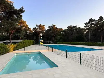 a swimming pool with a fence around it at Boshuisje June - middenin de natuur op een uurtje rijden van Antwerpen en Maastricht in Balen