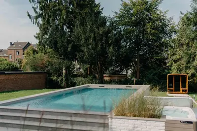 a swimming pool in a yard with trees at Designer Hôtel in Heusy